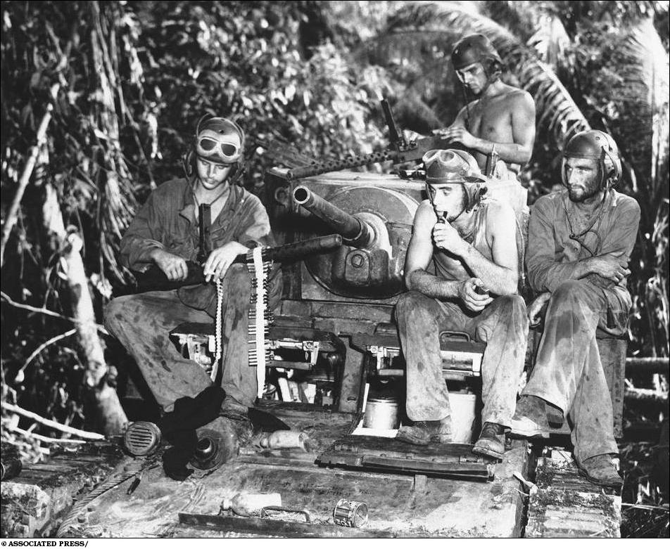 Sept. 11, 1943: After three days of fighting on the front lines on Munda, a Marine's tank crew take a rest, during which their machine guns are overhauled. This platoon wiped out 30 Japanese pill boxes. Left to right are: Pfc. Arnold McKenzie, Los Angeles, Calif.; Joseph Lodico, Sharon, Mass.; Pvt. Noel M. Billups, Columbus Ohio; and Staff Sgt. Douglas Ayres, Los Angeles. (AP Photo)